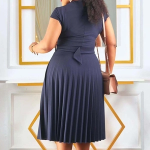 Détail d'une robe plissée bleu marine à manches courtes avec ceinture nouée à l'arrière