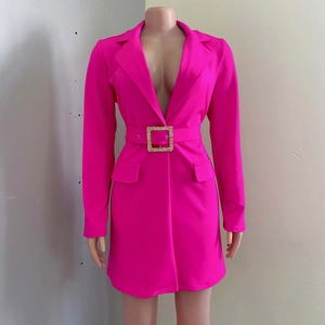 Dettaglio dell'abito blazer rosa acceso con fibbia dorata e design della vita sfiancato
