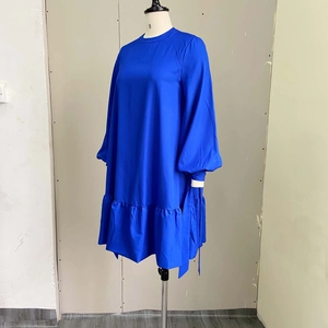 Detail of bright blue puff sleeve dress with elegant ruffled hem and woven fabric