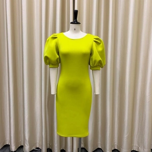 Détail des manches bouffantes et de la coupe ajustée sur une robe de soirée jaune néon