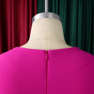 Detailed close-up of invisible back zipper on rose red pleated square neck dress