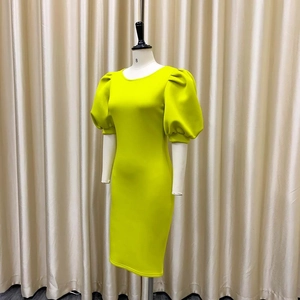 Détail de la robe de cocktail vert lime avec manches bouffantes et coupe moulante élégante