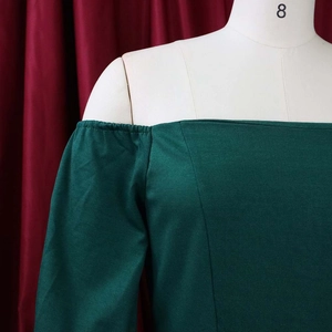 Close-up of the elegant off-shoulder neckline and bell sleeves on a dark green dress