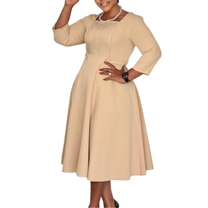 Detail of square neckline and vertical pleats on beige high waist A-line dress
