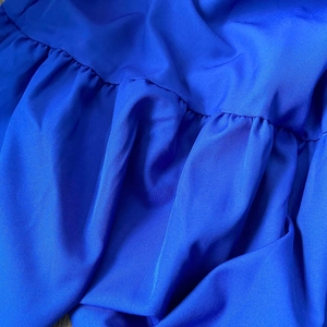 Close-up of royal blue fabric featuring elegant pleated details and smooth texture