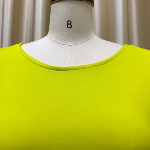 Gros plan détaillé de la robe à manches bouffantes vert fluo montrant la texture du tricot
