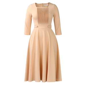 Detail of square neck beige dress with vertical pleats and decorative pearl buttons
