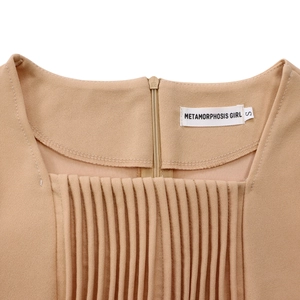 Detailed view of the square neckline and pleated texture on the apricot high-waist dress
