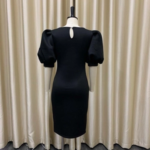 Détail de la découpe au dos et des manches bouffantes de cette robe midi noire ajustée