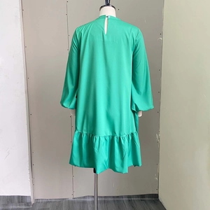 Detail view of the green lantern sleeves and ruffled hem on a loose casual dress