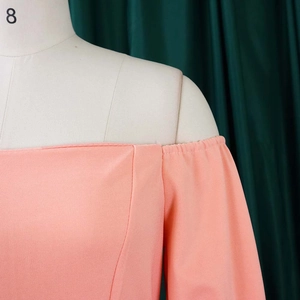 Detail of coral orange off-the-shoulder neckline with elastic pleated texture for women