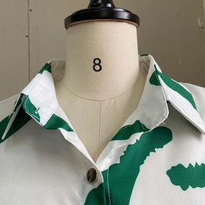 Detail of classic collar and green marble print on white button-down shirt dress