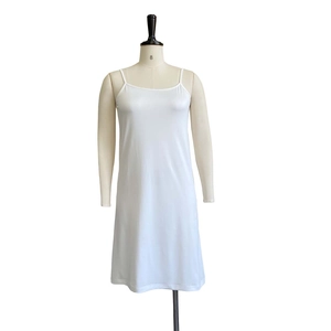 Detailed view of white satin strap dress fabric and minimalist sleeveless design
