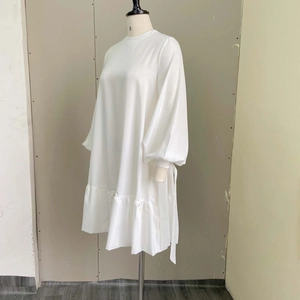 Detail of white puff sleeve midi dress featuring elegant satin texture and tie decoration