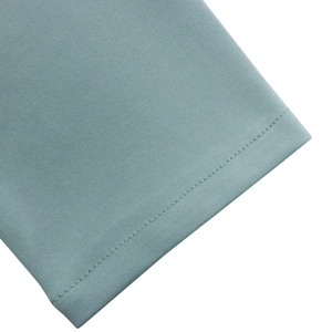 Vue détaillée de la couture et de la texture du tissu vert sauge sur la robe ajustée