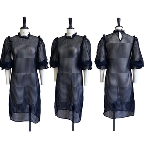 Detail of black hollow mesh dress featuring ruffled stand collar and puffed half sleeves