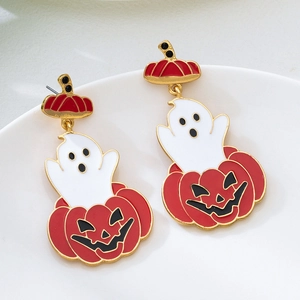 Macro detail of ghost and pumpkin earrings with gold plating and drip glaze finish