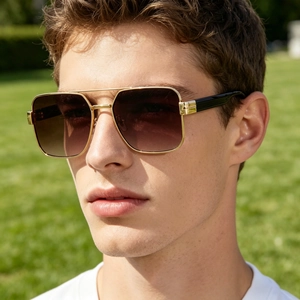 Close-up detail of men's fashionable square gold metal sunglasses with brown lenses