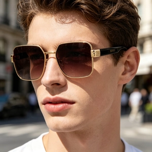 Close-up of stylish men's square metal frame sunglasses with gradient brown lenses.
