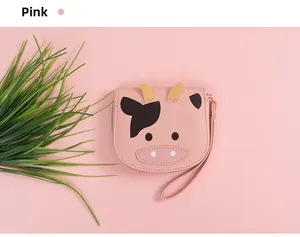 Pink cartoon cow coin purse with zipper closure and wrist strap on pink background