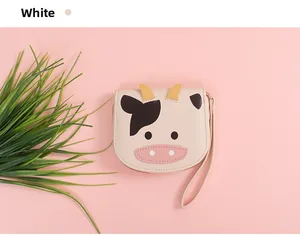 Detail of cartoon cow coin purse in white with black spots and zipper closure