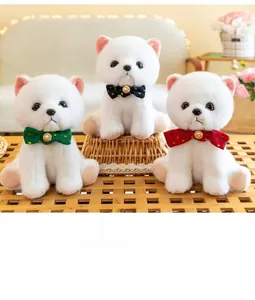 Close-up of three white fluffy puppy plush toys with colorful polka dot bowties