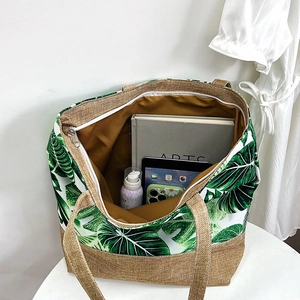 Detail of tropical leaf print tote bag showing spacious interior and secure zipper closure