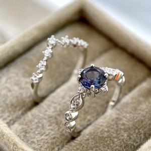 Macro shot of engagement ring set with blue round center stone and matching V-shaped band