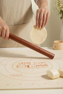 Detail of ebony wood rolling pin on silicone baking mat with measurement scales