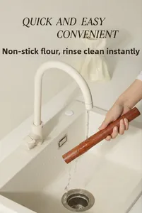 Ebony wood rolling pin being rinsed under running water to show easy cleaning
