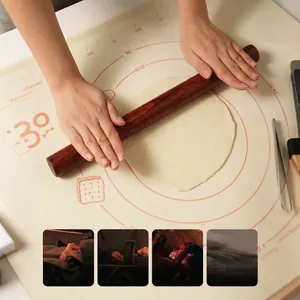Polished ebony wood rolling pin for dough on a silicone mat with measurement markings