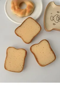 Detailed texture of toast-shaped kitchen sponges showing porous surface and realistic edges