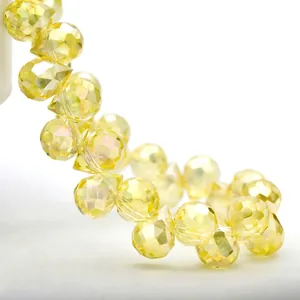 Macro detail of yellow faceted K9 crystal teardrop beads with brilliant cut surfaces