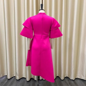 Detailed view of magenta evening dress featuring double ruffle sleeves and asymmetrical hemline