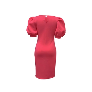 Détail de la robe moulante rose avec manches bouffantes et fermeture bouton au dos