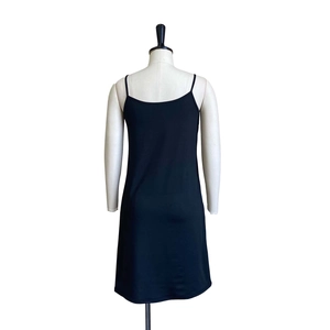 Detailed close-up of a minimalist black camisole dress with slim straps and bodycon fit