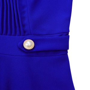 Macro shot of royal blue pleated fabric featuring an elegant pearl gold buckle
