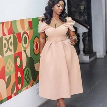 Detail of peach puff sleeve dress with a large flared hem and belted waistline