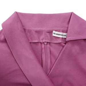 Détail du décolleté en V croisé avec fermeture éclair et étiquette sur la robe rose