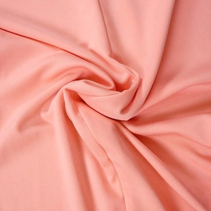 Macro detail of coral orange knitted fabric with fine grid texture and soft draping effect