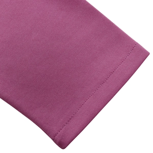 Détail de la couture des manches et texture en maille du vêtement rose à col en V