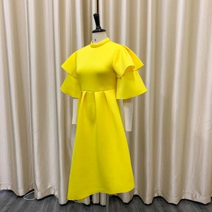 Detail of elegant bright yellow dress featuring double ruffles and stand collar design
