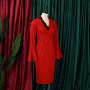 Close-up of red dress showing V-neck lapel with black floral pearl embellishments