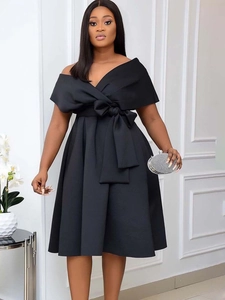 Elegant black off-shoulder V-neck dress with a large waist bow and pleated flared skirt