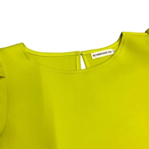 Détail de l'encolure ronde et de l'étiquette de marque d'une robe moulante vert citron