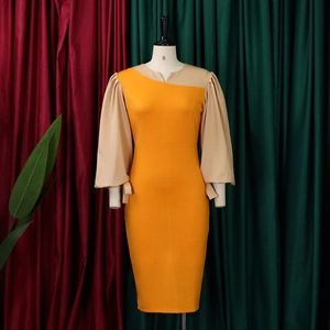 Detail of a color-block midi dress featuring yellow body and beige lantern sleeves