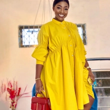Detail of yellow puff sleeve dress featuring high collar, button front and cinched waistline