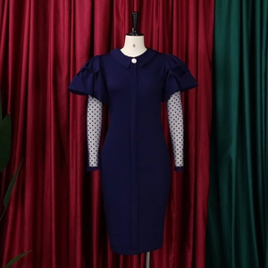 Detail of navy dress with puff sleeves, polka dot mesh layering and pearl button accent