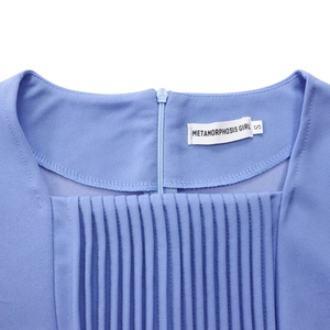 Detailed view of blue square neck dress with vertical pleats and invisible zipper closure