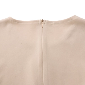 Gros plan sur la fermeture éclair invisible et texture tissée du col de robe beige